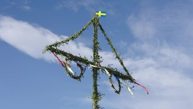 Raise midsummer pole on midsummer eve in Sweden. Swedish decorated st&aring;ng