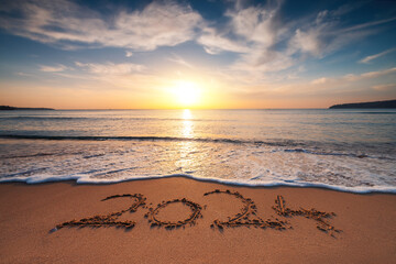 Happy New Year 2024 concept, lettering on the beach. Written text on the sea beach at sunrise. - 677273024