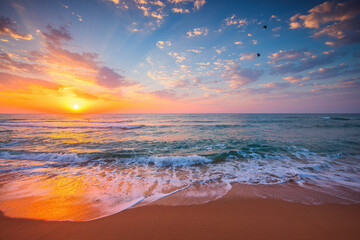 Tropical color island beach sunrise with splashing waves on the sea sand