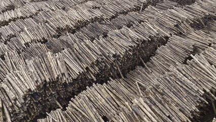 Slow moving aerial Drone video of lumber yard with rows upon rows of freshly cut logs stacked in piles at a lumberyard (HDR 4K ProRes)