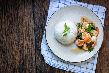 cooked rice with Stir fried shrimp basil,thai food.Basil fried rice with shrimp, stir-fried on a wooden table.