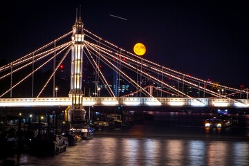 Fototapeta na wymiar Beautiful shot of an illuminated bridge under the golden moon in London