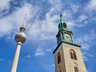 Fototapeta na wymiar Berlin TV Tower, called Berliner Fernsehturm, and St. Mary’s Church Bell Tower, Marienkirche Belfry. Near Alexanderplatz. Mitte, Berlin, Germany, Europe