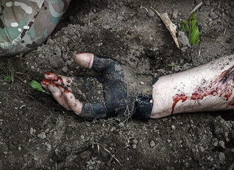Hand of a wounded soldier covered in blood