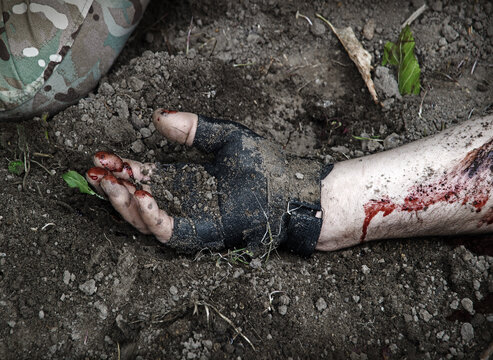 Hand of a wounded soldier covered in blood
