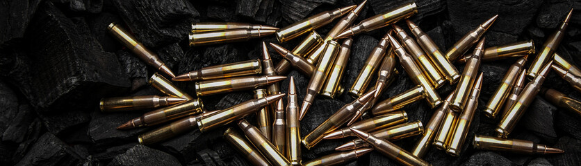 Cartridges for automatic carbine caliber .223 on charcoal. Ammunition for automatic and semi-automatic rifles. Dark back