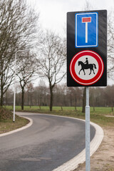 Dutch traffic sign with a dual function. The upper symbol indicates you are entering a dead-end road. The lower signal indicates it is forbidden for horse riders to enter this road.