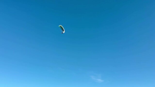 Paragliding. Paraglider soaring, flying in clear blue sky