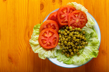 Vegetables in a plate appetizer cucumber, tomato, peas.
