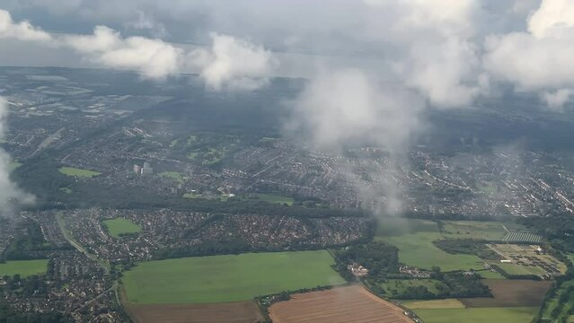 Looking through aeroplane window. Aircraft point of view flying above Liverpool, England between A562 and M62 highway.