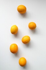four lemons on top of each other on a white surface