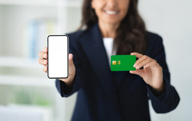 Cropped of woman showing phone and credit card