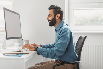 Focused indian businessman working on computer in office
