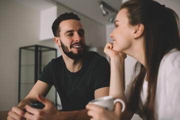 Smiling young couple talking in kitchen