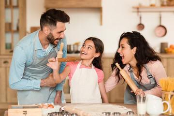 Family fun with rolling pins in kitchen