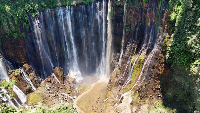 Aerial 4K footage of Tumpak Sewu also known as Coban Sewu waterfall and Semeru volcano mountain. A jungle waterfall in East Java,  Indonesia
