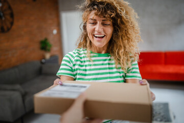 one caucasian female adult woman at home receiving package by post product he ordered online or special gift happy smile real people delivery service concept