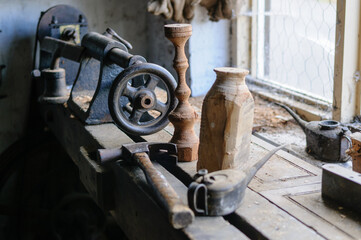 Old fashioned wood turning lathe and tools in a workshop