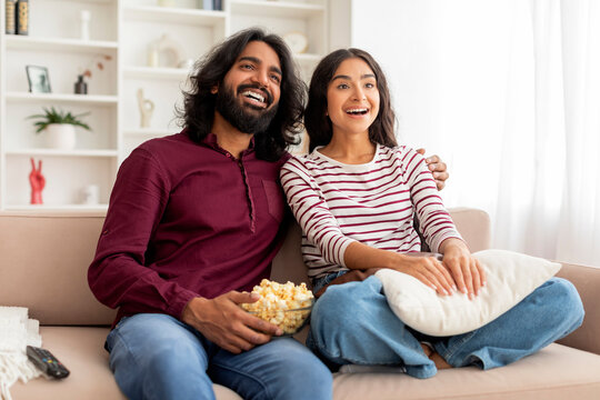 Portrait Of Happy Relaxed Indian Couple Enjoying Movie At Home