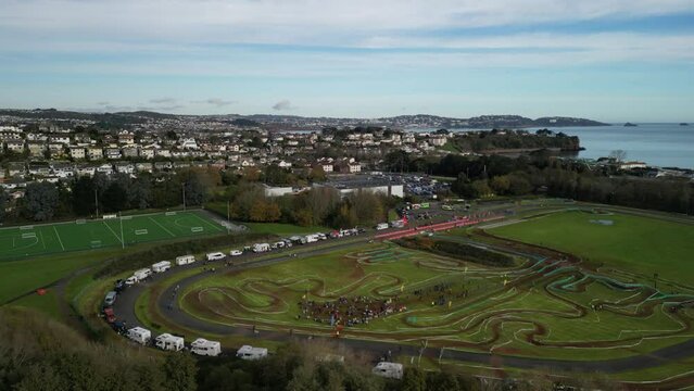 Paignton, Torbay, South Devon, England: DRONE VIEWS: A cyclo-cross event at Torbay VeloPark with Paignton skyline and Torbay coastline in background. Torbay is a popular UK holiday resort (Clip 2). 