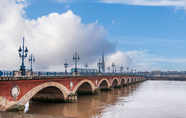 The stone bridge and a passing tram, in Bordeaux in Gironde, Nouvelle-Aquitaine, France