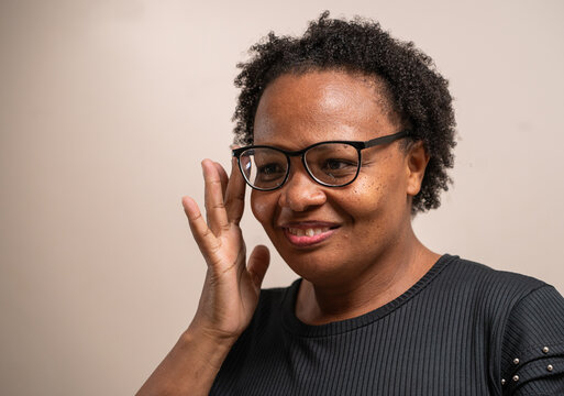 Black Woman Touching On Her Glasses On Pastel Background.