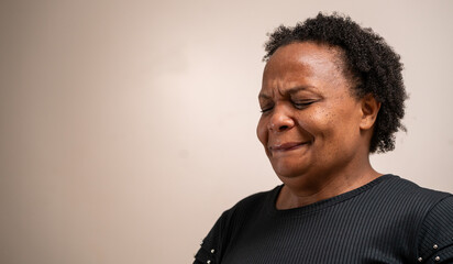 Fototapeta premium Black woman with eyes closed with sad expression on pastel background.