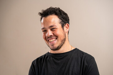 Unshaven young man smiling on pastel background.