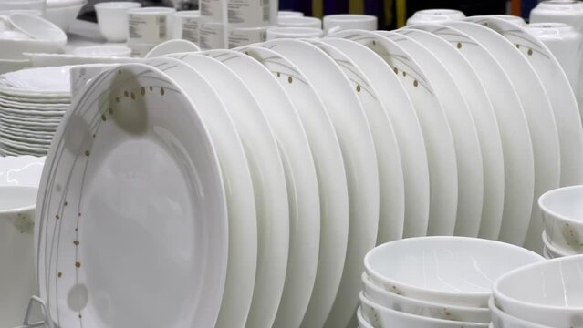 Round plates lined up on the shelf of a crockery store or tableware shop