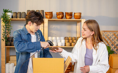 Two adult online couple sellers scanning barcode to check product price for making payment before packing to box for delivery. Small Business, Entrepreneur Concept.