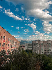 cloudy summer day in Almaty, houses on the background of mountains