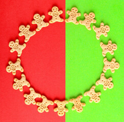 Mini gingerbread men cookies in shape of circle over green and red background.
