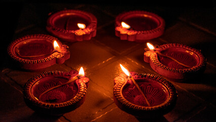 beautifully lit diyas casting a warm and vibrant glow, symbolizing the joy and spirituality of a festive celebration. Low Key Diya Photograph