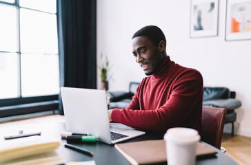 Obraz na płótnie Canvas Happy black man surfing laptop during work