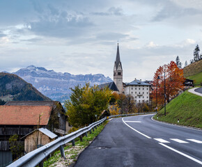 Fototapeta na wymiar Autumn Dolomites village and old church, Livinallongo del Col di Lana, Italy.