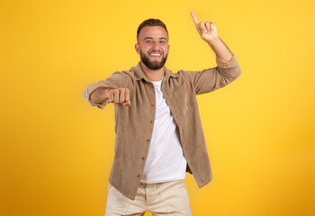 Positive young caucasian man with beard in casual point finger up and high five with fist gesture