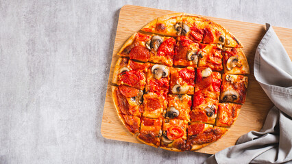 American St. Louis Style pizza with bacon, mushrooms and tomatoes on a board top view web banner