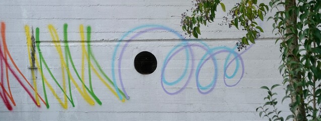 Muro urbano con graffiti disegnati con spray vernice colorata