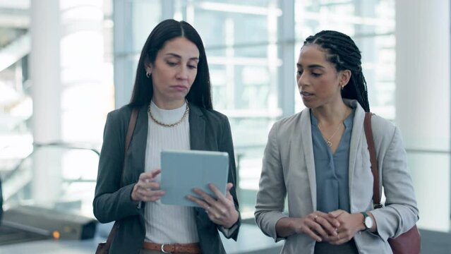 Business, women and tablet for travel schedule while walking in an airport checking info together. Meeting, brief and female team online for airplane information, compliance or reading flight details