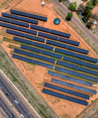 Aerial view, solar panels above crops ensuring fresh vegetables for the city situated near a busy...