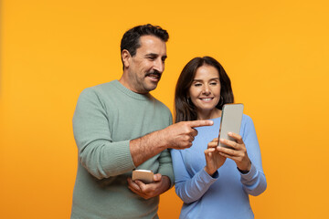 Positive old european family watch video on phone, point finger at smartphone