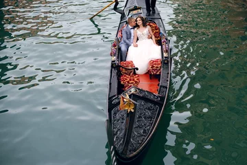 Fotobehang Gorgeous Wedding couple swimming on the gondola in Venice, Italy and enjoying of the beautiful old architecture © WellStock