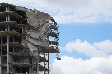 Industrial demolition of a multi-storey building, a building with collapsed floors against a blue...