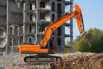 Building destruction, demolition of a building by a red excavator