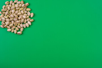 pu&ntilde;ado de pistachos en la esquina superior con fondo verde