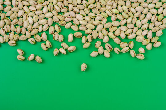 margen superior llenos de pistachos sobre fondo verde