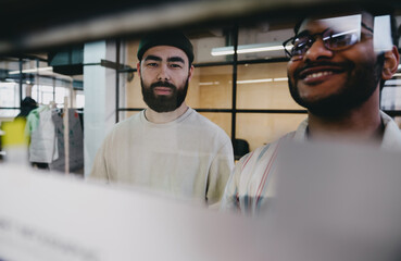 Smiling bearded young men working in office