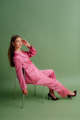 Fashionable beautiful confident woman wearing trendy pink satin suit blazer, trousers, pointed toe...