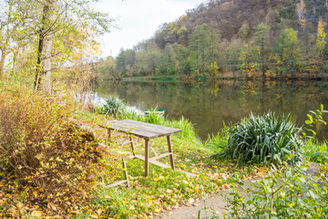Fototapeta na wymiar Quiet bench at Park by river Berunka Fall Autumn Trees. Autumn morning light