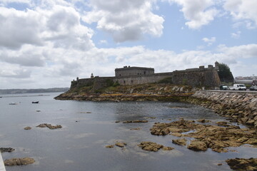 Fototapeta na wymiar views of the castle of san anton in la coruña, spain. Blue sky with clouds and part of the sea and pier. nature.